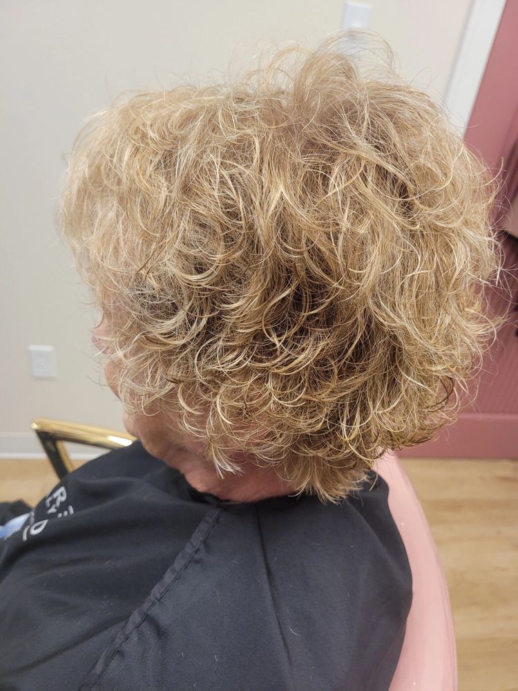 After — Wispy, undefined layers reshaped into voluminous, springy curls with a precision cut.